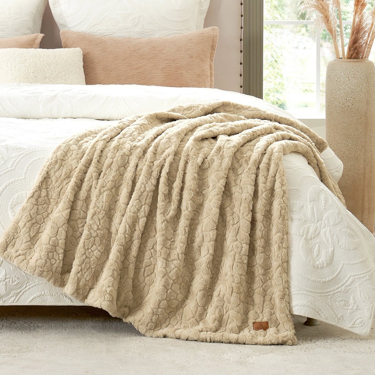 Khaki textured blanket draped over a bed with pillows in a cozy bedroom setting. #color_Khaki