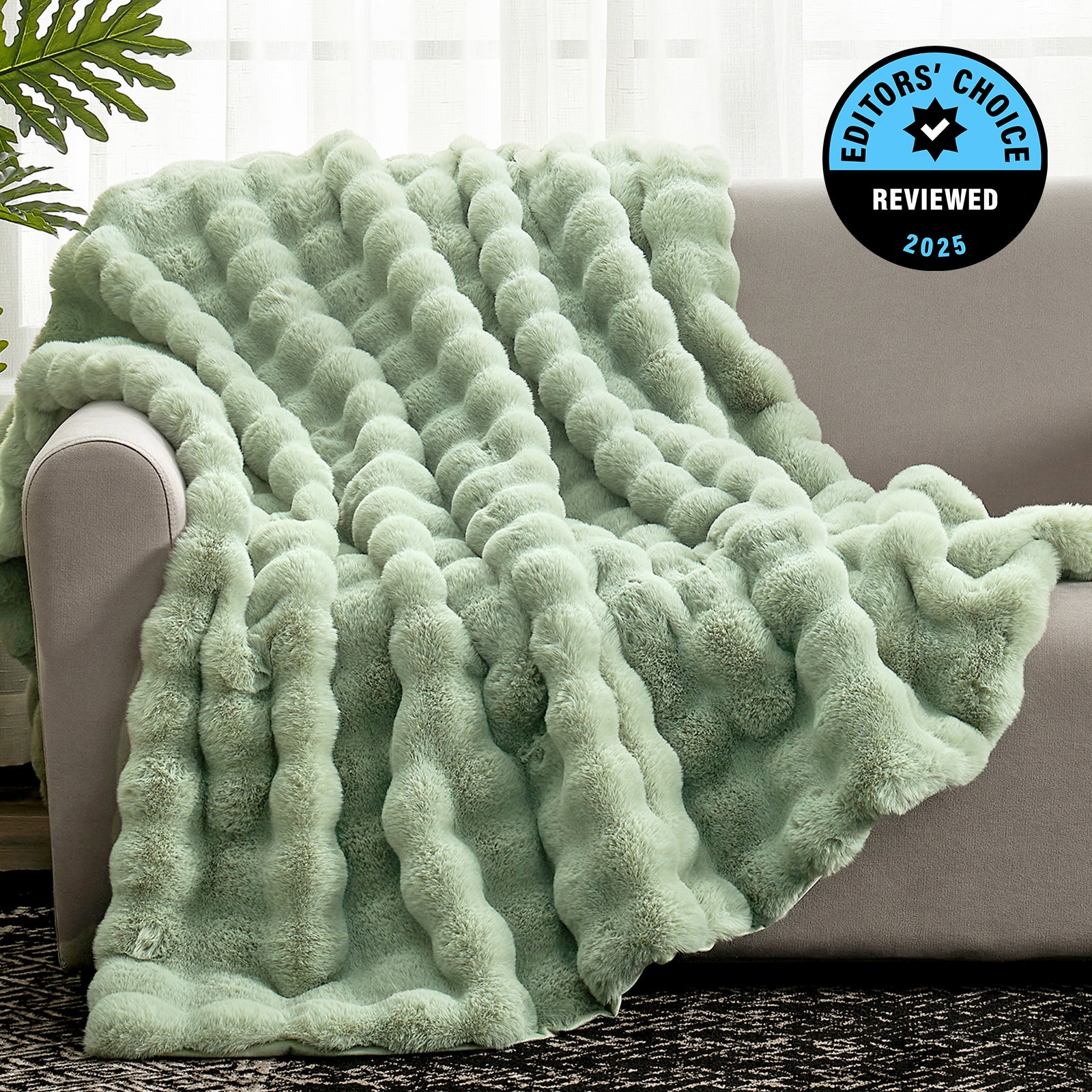 Green textured blanket draped over a couch with 'Editors' Choice' badge in the corner. #Color_Sage Green