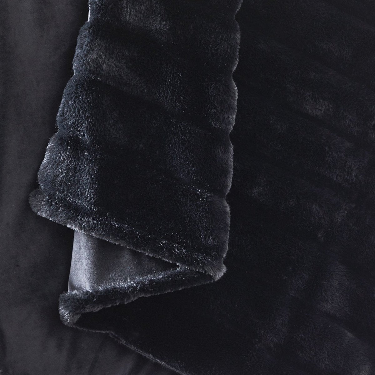 Close-up of Cozy Bliss faux fur blanket texture with ultra-soft hand feel #color_Black