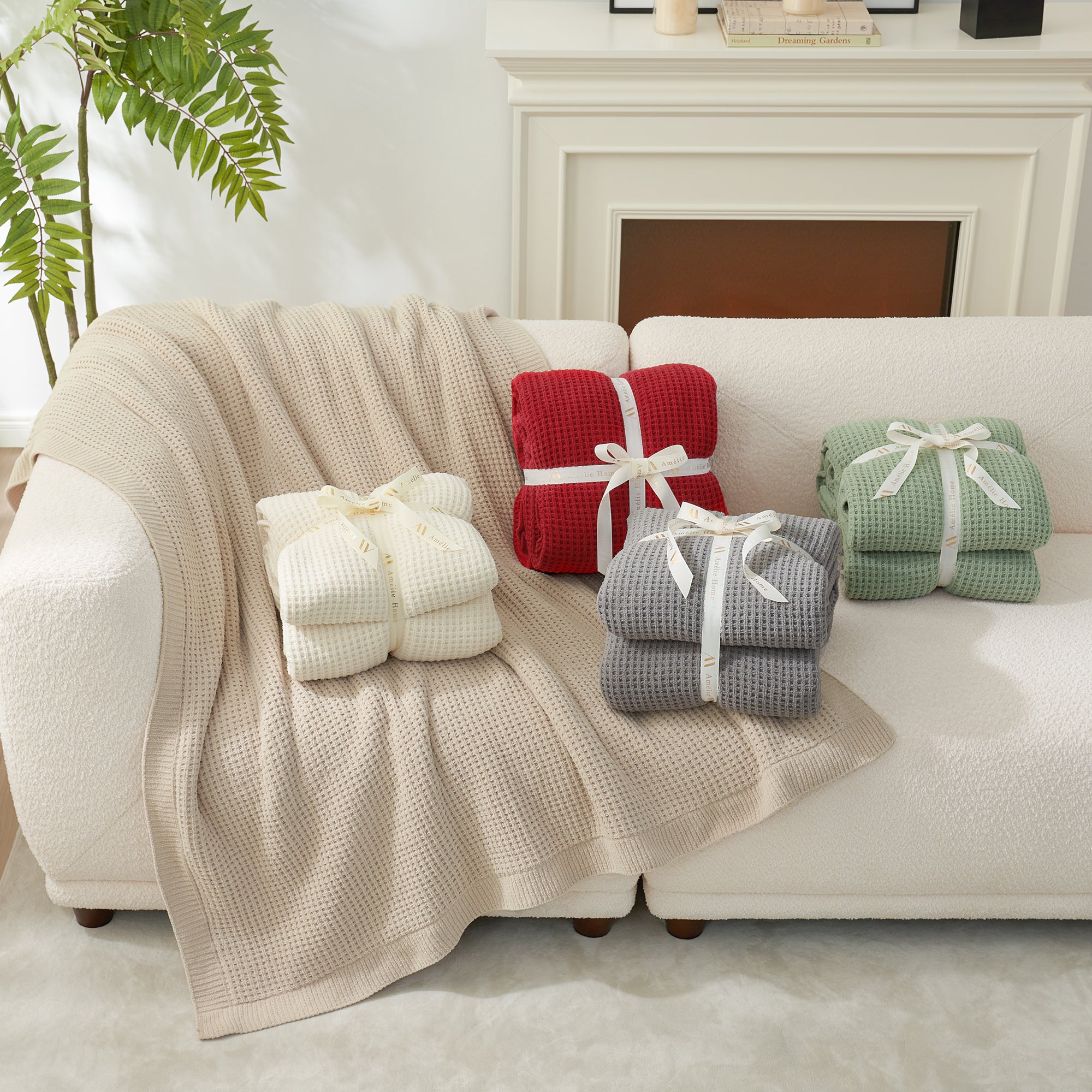 Stacks of folded blankets in various colors on a sofa next to a fireplace.