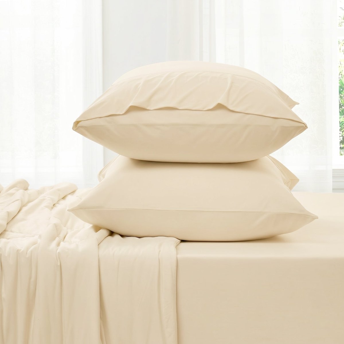 Khaki bedding set with two pillowcases and fitted sheet against a white curtain background in side view.#color_Khaki