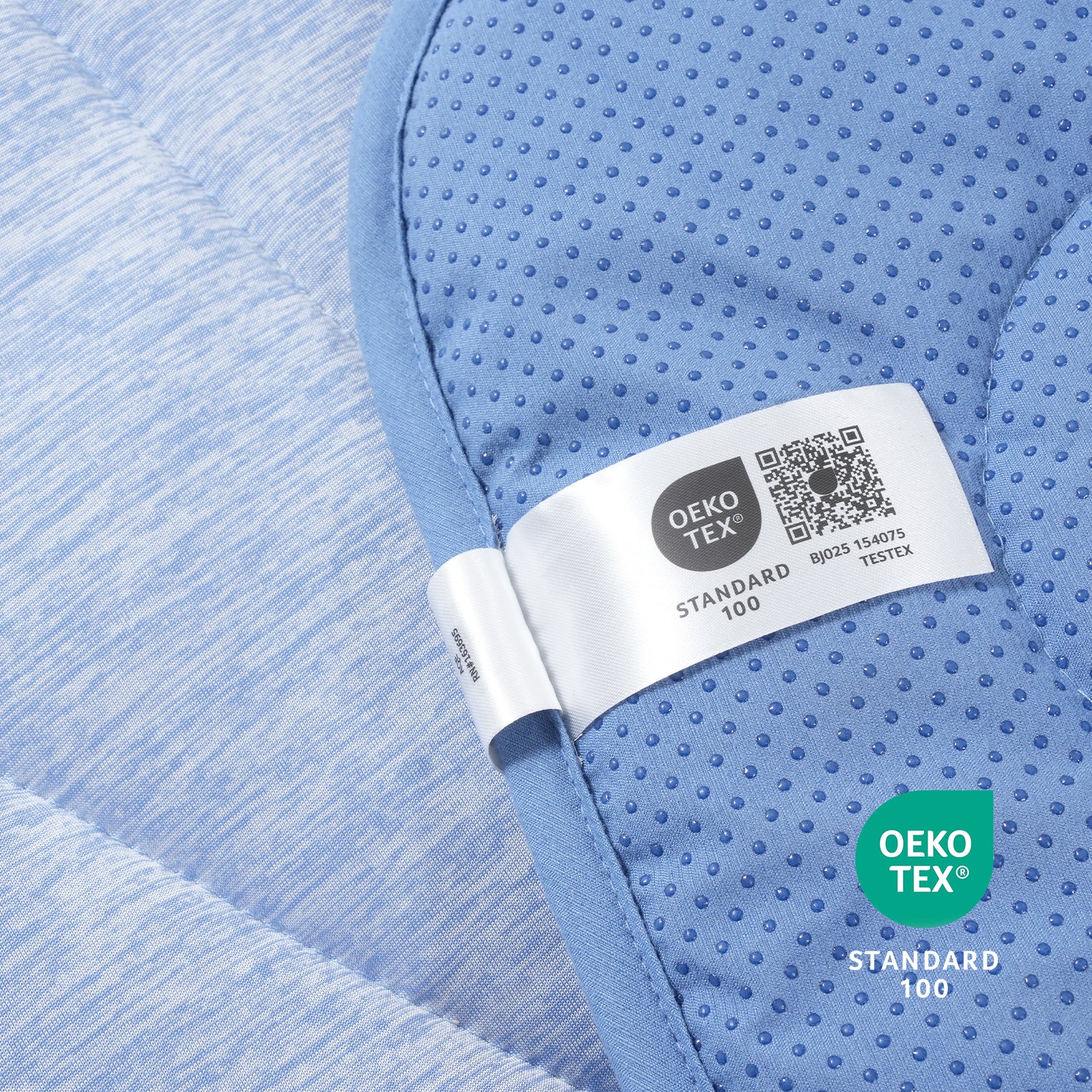 Close-up of a blue textured fabric with an Oeko-Tex label.#color_Misty Blue