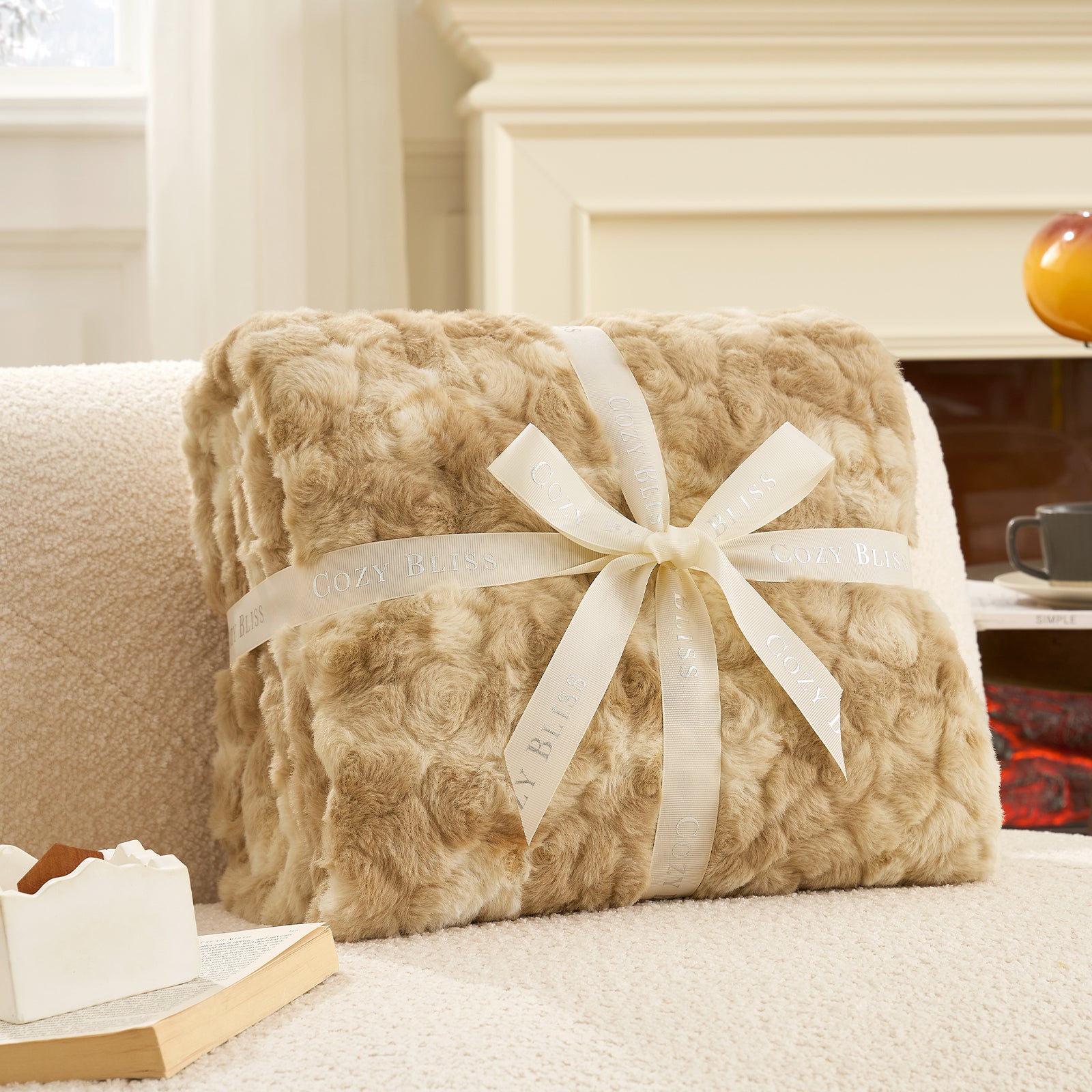 Faux fur lanket with a white bow on a couch in a cozy living room setting.#color_Tie-dye Khaki