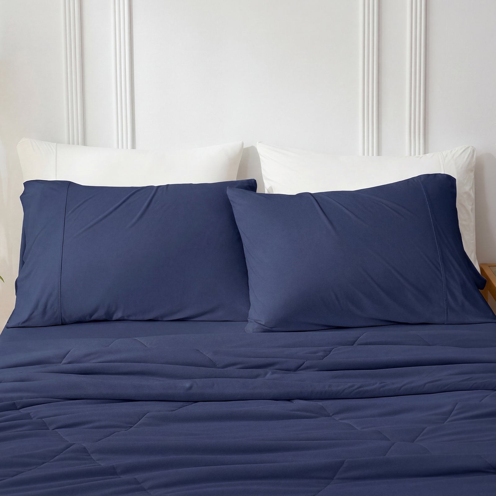 Dark blue cooling pillowcases on bed with cozy comforter.#color_Dark Blue