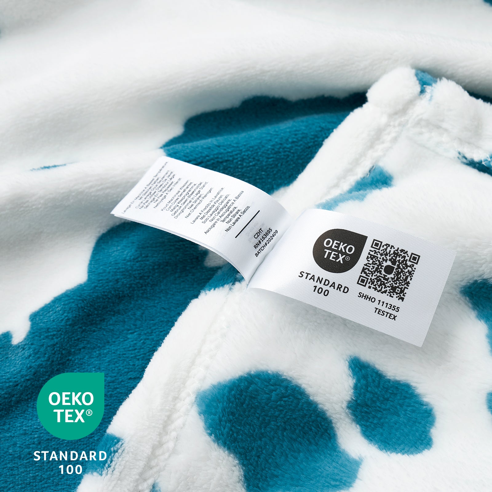 Close-up of a blue and white patterned fabric with OEKO-TEX labels.  #color_Blue