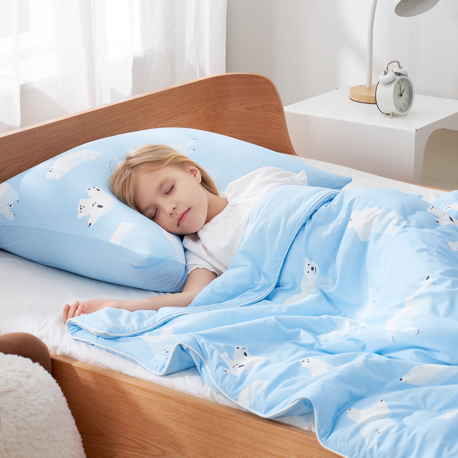 Child sleeping with polar bear cooling comforter and pillow.#color_Polar Bear