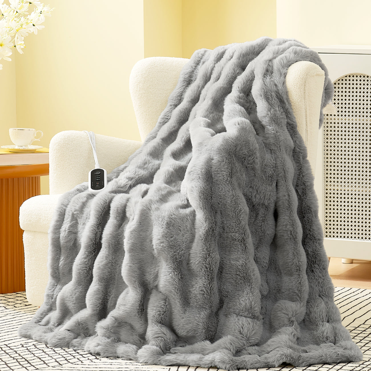 Gray fluffy blanket draped over a chair in a cozy living room. #color_Light Grey