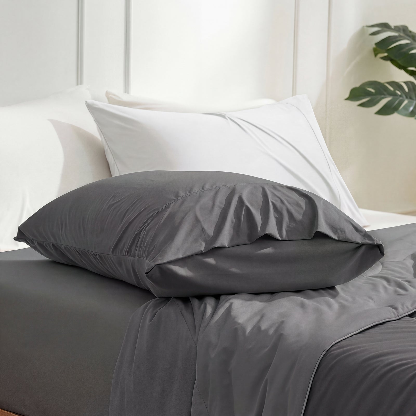Charcoal grey cooling pillowcases on bed, showcasing smooth, breathable fabric for summer comfort. #color_Charcoal Grey