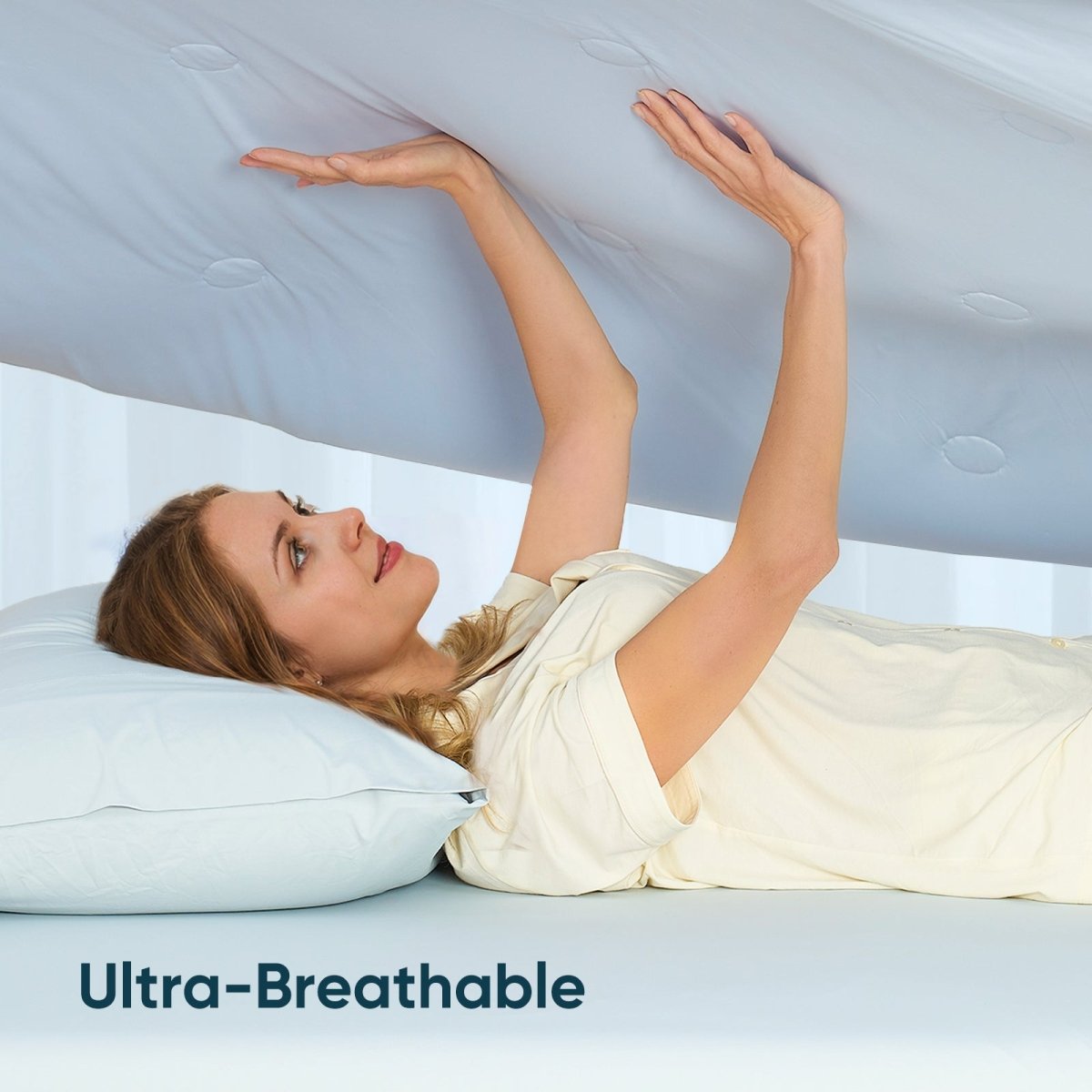 Women touching breathable cooling comforter.#color_Cool Blue