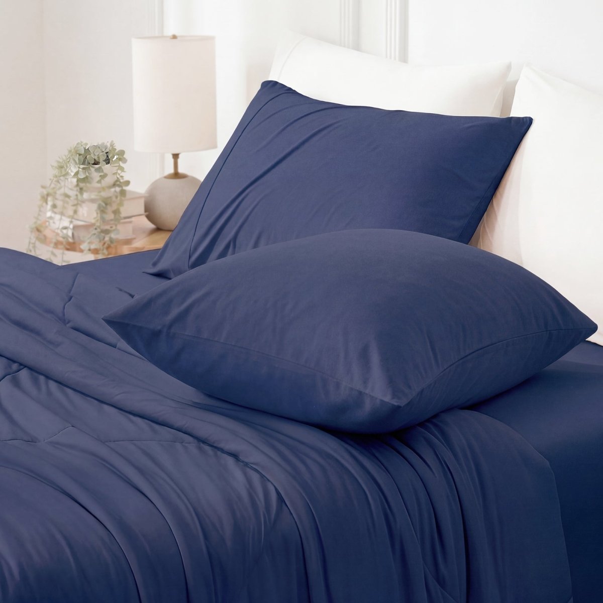 Navy blue cooling pillowcases on bed, showcasing smooth, breathable fabric for summer comfort. #color_Navy Blue