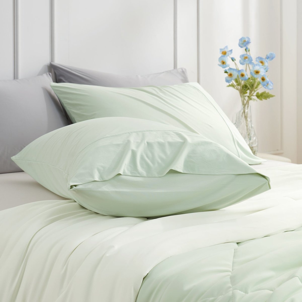 Cooling pillowcases in mint green on a bed. Breathable, soft bedding for comfortable sleep. #color_Light Mint Green