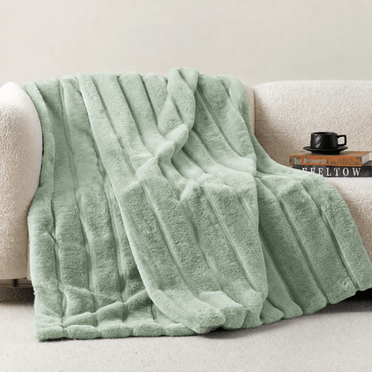 Cozy Bliss sheared faux fur throw blanket draped over a sofa, showcasing elegant ribbed texture #color_Sage Green