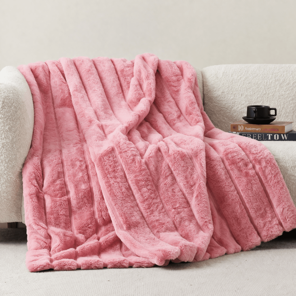 Cozy Bliss sheared faux fur throw blanket draped over a sofa, showcasing elegant ribbed texture #color_Pink